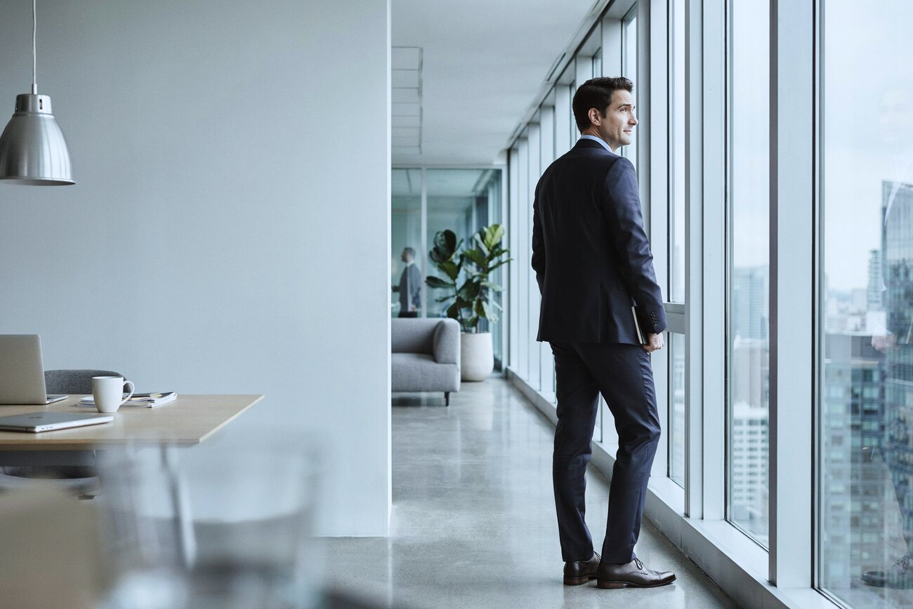A technology leader looking out over the city from an office window