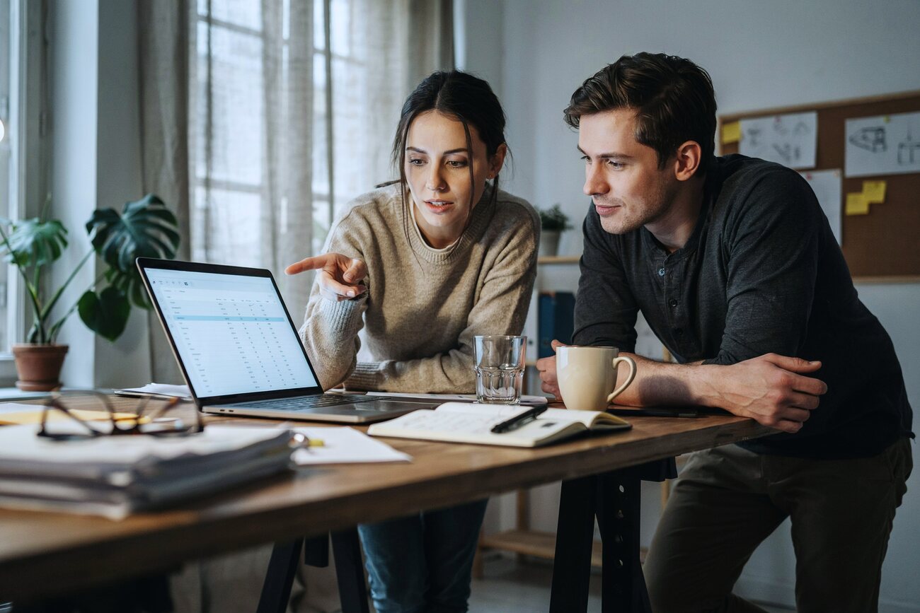 Two colleagues working together over a laptop